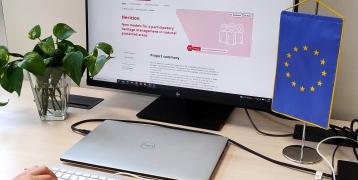 Person typing at computer in front of project website